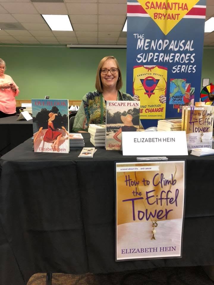 Elizabeth Hein with her novels at the Local Author Book Fair.