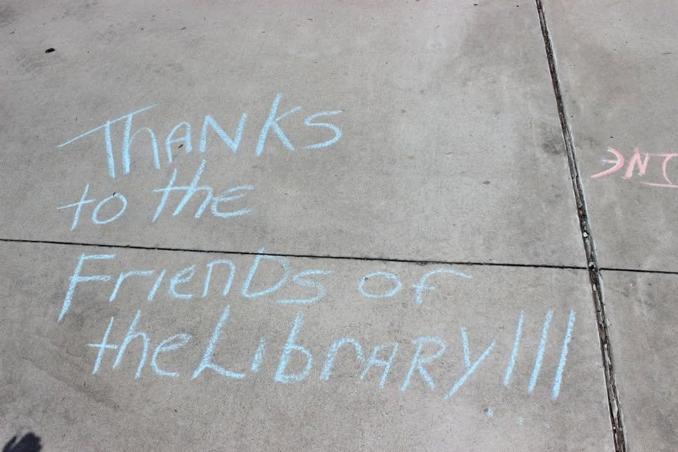 Sidewalk chalk reading Thanks to the Friends of the Library